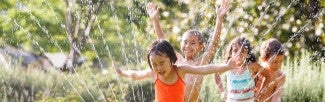 Kids running through sprinklers