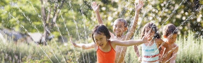 Kids running through sprinklers